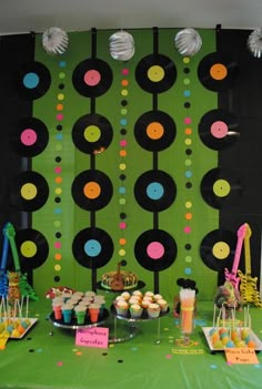 a green table topped with lots of cupcakes