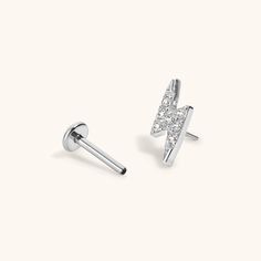 A little bolt of inspiration and energy to carry with you wherever you go. Introducing the Nap Earrings Collection - our signature push pin flat backs designed for 24/7 poke-free wear! Made from medical grade titanium to be safe for sensitive skin. And, for the first time, we made them in 20g (aka the same thickness as traditional earrings), so they’re perfect for lobe piercings! The push pin earring posts are easy to insert and remove from your ear, and the flat back makes them super comfortabl Nap Earrings, Lightning Bolt Design, Lobe Piercings, Cartilage Piercings, Tragus Conch, Cartilage Earrings Stud, Lightning Bolt Earrings, Flat Back Earrings, Titanium Earrings