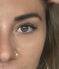 a woman with yellow nose piercings on her nose