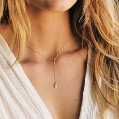 "Our lariat necklace is perfect minimalist jewelry. This dainty necklace is perfect with your favorite tee or your little black dress. A tiny cubic zircon drop adorns a 14kt gold filled chain.  D E T A I L S *Tiny cubic zircon drop - gold over sterling silver  *2 inch drop  *Dainty link chain *100% 14kt gold dainty link chain  LENGTH *The standard length is normally 18\". *Model is wearing a 16\" in Photos. HOW TO PERSONALIZE *Select your choices from the drop down menu to create your custom des Dainty Rose Gold Lariat Necklace, Dainty Lariat Drop Necklace With Adjustable Length, Simple Adjustable Jewelry As A Gift, Minimalist 14k Gold Filled Dangle Charm Necklace, Adjustable Lariat Drop Necklace In Minimalist Style, Minimalist Dangle Jewelry With Delicate Chain, Minimalist Adjustable Lariat Drop Necklace, Dainty Lariat Backdrop Necklace With Adjustable Length, Adjustable Minimalist Lariat Drop Necklace