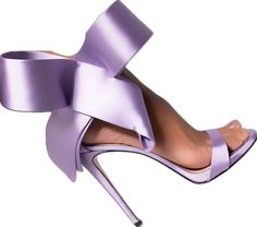 a woman's foot wearing purple high heels with a large bow on the side