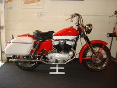 a red and white motorcycle parked in a garage