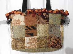 Beautiful Handmade Patchwork Tapestry Tote Bag.  This  has about 10 different mixed colored and designed patches in a heavy duty tapestry material. The top of the bag  is bordered with a 1 inch ruffled  ribbon all around and on each side of bag up top is a lovely Black Chiffon Bow. The inside of bag is lined   with a sturdy fabric  with a burgundy background and lovely colored leaves. This is such a nice extra large strong  tote bag to use in so many different ways. The straps are a 1 1/2  inch Multicolor Tapestry Rectangular Bag, Tote Bag Patchwork, Patchwork Tapestry, Chiffon Bow, Burgundy Background, Colored Leaves, Oversized Tote Bag, Oversized Tote, Black Chiffon