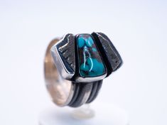 This piece features a piece of natural Turquoise balanced between two beautifully unique silver boxes. During your day, we envision this ring will remind you that balance leads to harmony, and your harmony is vital to your wellbeing. Perfect for any outfit, this ring wears well any day of the week. Natural Turquoise and .925/.999 silver. This ring is a size: 9(US) Setting size: 15X22mm (stone 14X8mm) Modernist Turquoise Jewelry Gift, Modern Silver Turquoise Ring As Gift, Modern Silver Turquoise Ring Gift, Turquoise Healing Properties, Silver Tops, Silver Box, Spiritual Guidance, Day Of The Week, Past Life