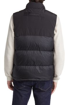 Weather it all in comfort and warmth wearing this vest featuring dual-entry pockets, a webbing grab strap at the upper back and 625-fill-power down insulation. 28" length (size Medium) Storm placket Stand collar Durable water-repellent (DWR) finish Lined, with 625-fill-power down 100% polyamide with 84% polyester, 16% cotton contrast Dry clean Made in Canada Black Vest With Padded Collar, Quilted Functional Winter Vest, Quilted Functional Vest For Winter, Functional Quilted Winter Vest, Functional Quilted Vest For Winter, Sleeveless Down Puffer Vest, Black Nylon Vest With Functional Pockets, Sleeveless Black Down Outerwear, Black Sleeveless Vest With Functional Pockets