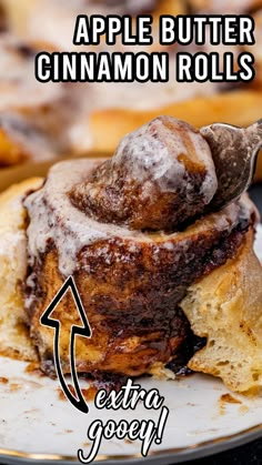 an apple butter cinnamon rolls on a plate with the words extra gooey written above it