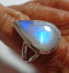 "Vintage rainbow moonstone ring with bright aqua blue to deep cobalt blue flash in a solid sterling silver ring The spectacular colors in this gem range from pale aqua to peacock blue to deep cobalt blue throughout the gorgeous pear moonstone. The pearl rainbow moonstone ring is a size 7. The ring is well crafted of solid sterling silver, and has an open back so the lovely moonstone energy can be felt on your finger. This vintage ring was stored carefully, and has been cleaned and polished. It i Teardrop Moonstone Gemstone Ring, Fusion Style Moonstone Gemstone Jewelry, Fusion Style Oval Moonstone Ring For Anniversary, Unique Moonstone Gemstone Ring For Anniversary, Fusion Style Oval Moonstone Ring, Fusion Style Oval Moonstone Ring Gift, Fusion Style Moonstone Gemstone Ring For Anniversary, Moonstone Ring With Large Round Stone, Fusion Style Anniversary Moonstone Gemstone Ring