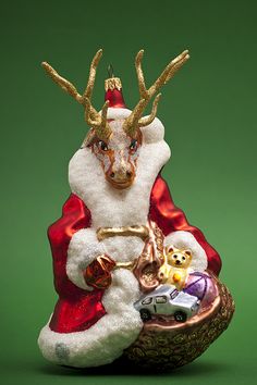 a christmas ornament with a reindeer and car on it's back, in front of a green background