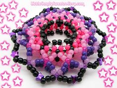 several bracelets made out of plastic beads and black, pink, and purple beads