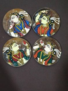 four glass coasters with paintings on them