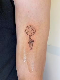 a person with a tattoo on their arm holding a hot air balloon in the shape of a hand