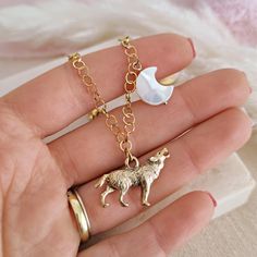 Can you hear this wolf howling to the white moon? This magic bracelet is made of 14k gold plated stainless steel chain and it features an antiqued gold pewter wolf and a Mother of Pearls moon bead. The perfect addition to your witchy style! DETAILS: - colors: white, antique gold, gold - materials: pewter, 14k gold plated brass, mother of pearls - length: customizable SHIPPING All orders will be shipped out through DHL Express or UPS Express. Please double check the address is correct before chec Moon Shaped White Bracelets For Gifts, White Moon Shaped Bracelets For Gift, White Moon-shaped Bracelets For Gifts, Moon Shaped White Bracelet For Gift, White Moon Shaped Bracelet Gift, Magic Bracelet, Wolf Bracelet, Descendants Oc, Wolf And Moon