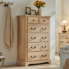 a bedroom scene with focus on the chest of drawers and sunflowers in vase