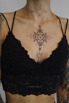 a woman with tattoos on her chest is wearing a bra top and black underwears