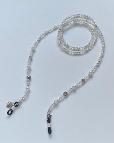 "Handmade Eyeglass Chain ✿ Made with glass crystal beads, glass beads, freshwater pearls, and metal accents ✿ Silver, iridescent white, and white ✿ 30.0\" ✿ Can be comfortably worn with sunglasses and eyeglasses. The rubber loops adjust to fit the frame." Beaded Clear Glass Glasses Chains, Clear Beaded Glass Glasses Chains, White Jewelry With Adjustable Glass Chain, White Beaded Glasses Chain As A Gift, White Glass Glasses Chains For Gift, White Glass Jewelry For Party, Elegant Handmade White Glasses Chains, Adjustable White Glasses Chains With Round Beads, Adjustable Silver Beaded Glasses Chain