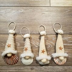 three christmas ornaments hanging from hooks on a wooden floor with shells and seashells