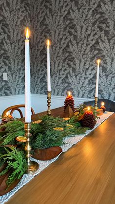 the table is set with candles and pine cones