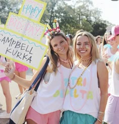 two girls holding up signs in front of them