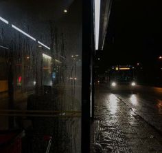 the rain is coming down on the street at night