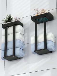 two black metal shelves with towels and plants on them