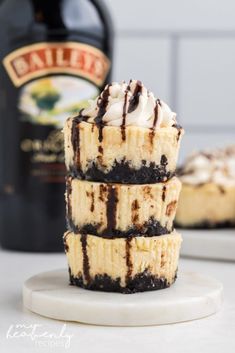 three cheesecakes stacked on top of each other next to a bottle of wine