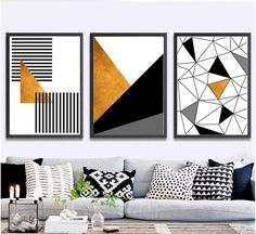 three black and white paintings hanging on the wall in a living room with couches