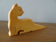 a wooden toy cat sitting on top of a table