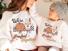 "Celebrate the magic of the fall season with our adorable Matching Mommy and Me Pumpkin Spice Fall Sweaters! Designed to capture the joy of togetherness, these sweaters feature the charming slogan \"We're a Perfect Match\" in a retro groovy font, accompanied by the cute graphic of a pumpkin and a pumpkin spice latte as retro mascot characters. If you're a fan of pumpkin spice lattes and love coordinating outfits with your little one, this Mommy And Me Fall collection is an absolute must-have. Whether it's for a Thanksgiving gathering or a casual day at the pumpkin patch, these Halloween Matching sweaters are sure to become your new fall favorites. These Pumpkin Sweatshirts are more than just a seasonal fashion statement; they represent the bond between mom and child. They make a delightful Playful White Sweatshirt For Fall, Playful Letter Print Sweatshirt For Fall, Playful Letter Print Sweater For Fall, Fun White Sweater For Fall, White Fun Sweater For Fall, Matching Cotton Sweatshirt For Fall, Cotton Fall Sweatshirt, White Family Matching Sweatshirt For Fall, Family Matching Cotton Sweatshirt For Fall