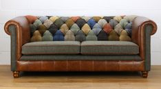 a brown leather couch with multicolored pillows on it's back and arms