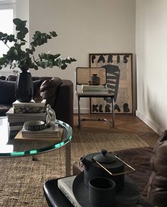 a living room filled with furniture and a glass coffee table topped with a potted plant