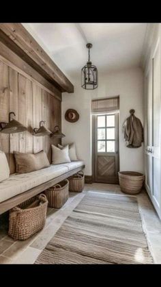 a wooden bench sitting in the middle of a hallway next to a door and baskets