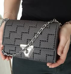 a woman holding a gray purse in her hands