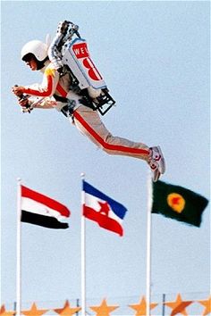 a man flying through the air while riding a snowboard in front of many flags