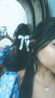 a woman taking a selfie in front of a mirror with her hair pulled back