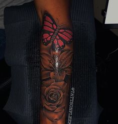 a woman's arm with a butterfly and rose tattoo design on the left forearm