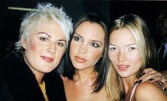 three women are posing for the camera with one woman holding her hand on her shoulder