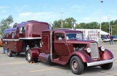 an old red truck parked in a parking lot