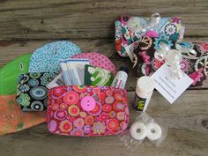 several small purses are sitting on a wooden table with sewing supplies and thread spools