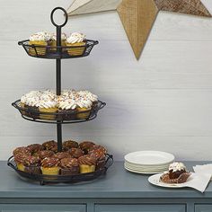 three tiered trays with cupcakes and other pastries on top of a table