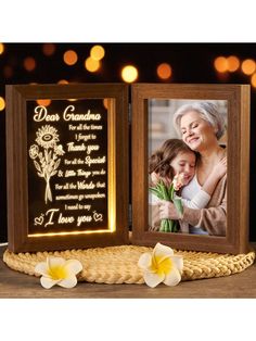 an illuminated photo frame with two flowers on it and the words dear grandma, i love you