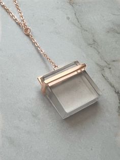 This stunning necklace features a square clear quartz crystal pendant that dangles gracefully from a sterling silver chain with a 14K rose gold plating. The combination of the clear crystal and the warm rose gold create a beautiful contrast that adds elegance and sophistication to any outfit. The quartz crystal is known for its healing properties, making this necklace not only a stylish accessory, but also a meaningful piece of jewelry that can be worn for any occasion. 925 Sterling Silver Rose Elegant Rose Gold Crystal Necklace With Delicate Chain, Elegant Rose Gold Crystal Necklaces With Adjustable Chain, Elegant Rose Gold Crystal Necklace With Adjustable Chain, Delicate Rose Gold Box Chain Necklace, Rose Gold Sterling Silver Rectangular Pendant Jewelry, Rose Gold Sterling Silver Jewelry With Rectangular Pendant, Rose Gold Sterling Silver Rectangular Pendant, Rectangular Rose Gold Sterling Silver Jewelry, Minimalist Rose Gold Crystal Pendant Necklace