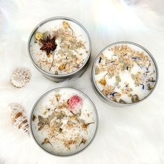 three tins filled with different types of food on top of a white fur covered floor