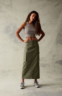 Step into your next adventure in the ultra-cool and casual Olive Stretch High-Waisted Cargo Midi Skirt. This utility midi skirt rocks cargo side pockets, a flirty back slit, and a stretchy fabrication for the perfect fit.   	Solid color midi skirt 	Stretch fabric 	High-rise 	Cargo pockets 	Zip fly closure 	Back slit 	Midi-length 	98% cotton, 2% spandex 	Machine washable 	Model is wearing a size 25 	Model measurements: 5’9.5” height, 34” bust, 24” waist, 35” hip Olive Green Cargo Skirt Outfit, Utility Skirt Outfit, Green Cargo Skirt Outfits, Unpolished Casual, Midi Cargo Skirt, Green Skirt Outfits, Utility Fashion, Cargo Skirt Outfit, Skirts With Sneakers