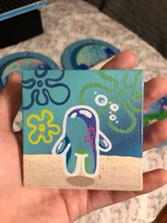 a hand holding up a piece of paper with an octopus on it