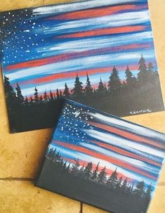 two canvases with trees and stars painted on them