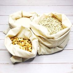 two bags filled with cereal sitting on top of a white wooden floor next to each other