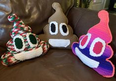 three crocheted pillows sitting on top of a brown leather couch next to each other