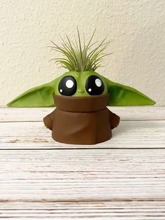 a planter that has been made to look like the child yoda from star wars