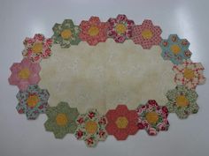 a table top with many different colored flowers on it and a white wall in the background