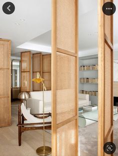 a living room filled with furniture next to a tall wooden book shelf on top of a hard wood floor